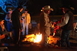People gathered around a fire at night, warming up and socializing.