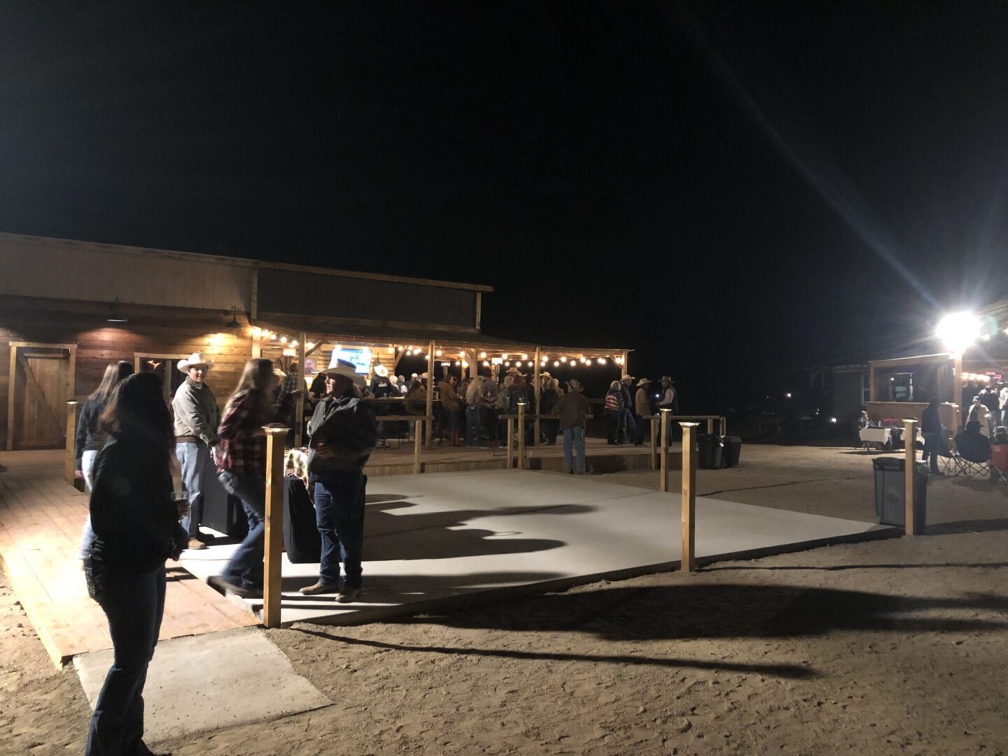People waiting in line outside a dimly lit building at night.
